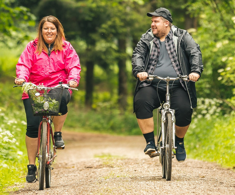 Fahrradbekleidung in großen Größen – Paar beim Radfahren in Übergrößen
