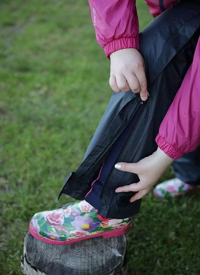 Regenhose Damen Übergröße – Seitenreißverschluss wird über Gummistiefel gezogen