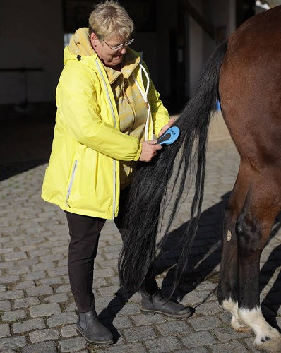 Windjacke Damen große Größen – Frau in gelber Outdoorjacke bei Alltagseinsatz im Freien