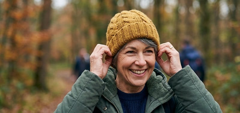 Frau zieht Beanie-Mütze auf und justiert den Sitz – Mützengröße richtig ermitteln