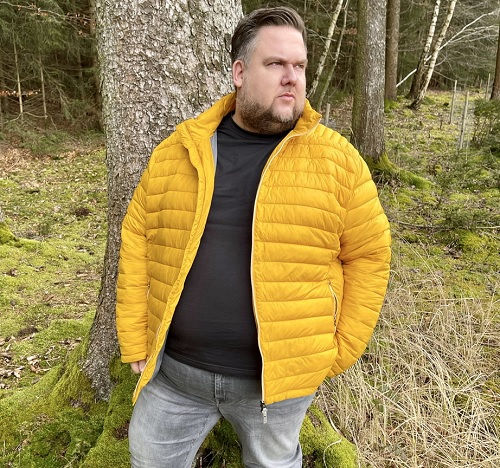 Steppjacke Herren Übergröße – Modell trägt gelbe Steppjacke im Wald