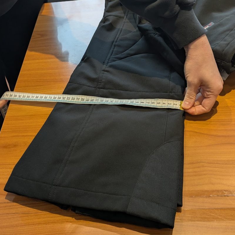 Ramona misst die Saumweite einer Hose flach am Beinabschluss