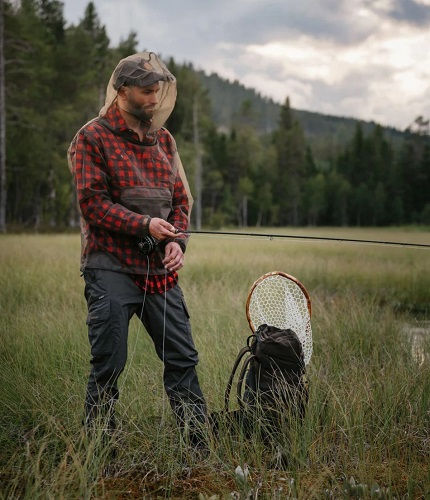 Stichfeste Kleidung im Einsatz – Angler mit Mückenschutz-Kopfnetz beim Fliegenfischen