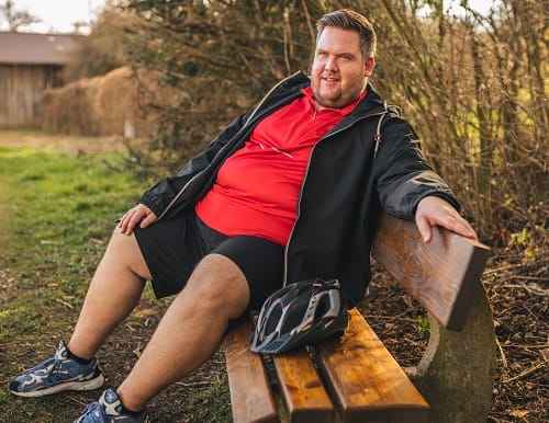 Bike Outfit XXL Herren – Gerri auf einer Radtour in Übergröße, rotes Fahrradtrikot mit Jacke und Helm