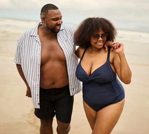 Bademode XXL – Paar am Strand in Badehose und Badeanzug Übergrößen