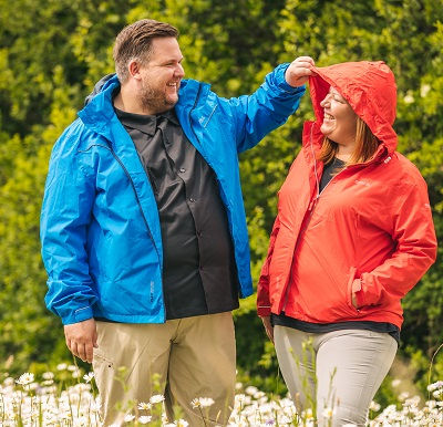 Mann und Frau in Pro-X Elements Regenjacken im Grünen